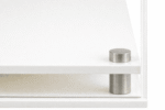 Closeup image of the corner of the white modern base, showing the acrylic and the stainless steel corner support