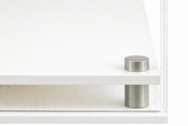 Closeup image of the corner of the white modern base, showing the acrylic and the stainless steel corner support