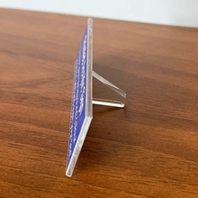 Side view of the Printed Acrylic Sign, shown on a wooden table with a grey backdrop
