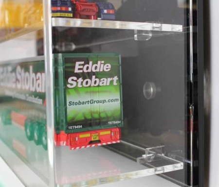 Side view of the model truck display case with a black back panel, showing the models inside
