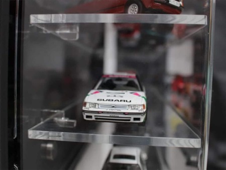 Side view of the 1:43 scale model car display case with a black back panel, showing the models inside
