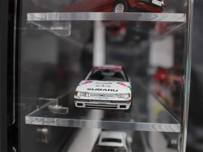 Side view of the 1:43 scale model car display case with a black back panel, showing the models inside