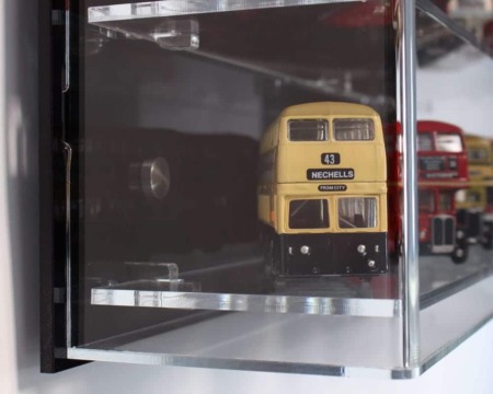 Side view of the 1:76 scale model bus display case with a black back panel, showing the models inside