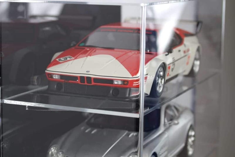 Side view of the 1:12 scale model car display case with a black back panel, showing the models inside