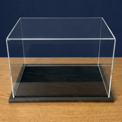 Image of an acrylic display case with a black wooden base and a black centra display area, shown empty.