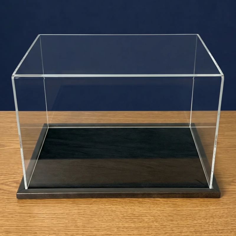 Image of an acrylic display case with a black wooden base and a black centra display area, shown empty.