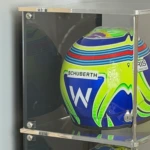 Side view of the stackable acrylic display case for a half scale F1 helmet, shows a helmet inside the display case