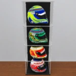 Image showing the display case with 3 additional layers, shows a total of 4 levels, each with a 1:2 scale model F1 helmet inside, shown on a wooden table in front of a grey wall