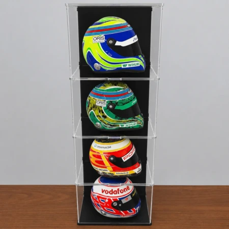 Image showing the display case with 3 additional layers, shows a total of 4 levels, each with a 1:2 scale model F1 helmet inside, shown on a wooden table in front of a grey wall